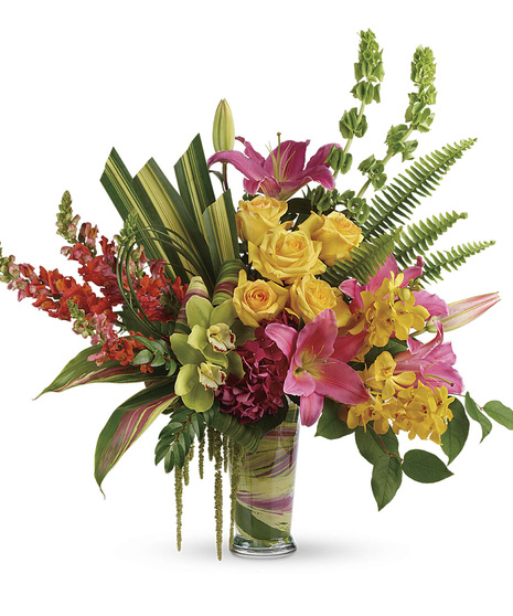 Bright roses, orchids, lilies and more in a leaf-lined glass vase